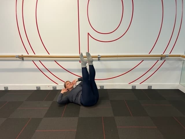 Personal trainer demonstrating leg lower ab exercise