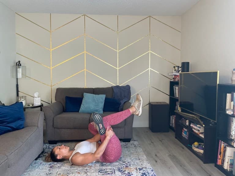 Personal trainer demonstrating supine piriformis stretch