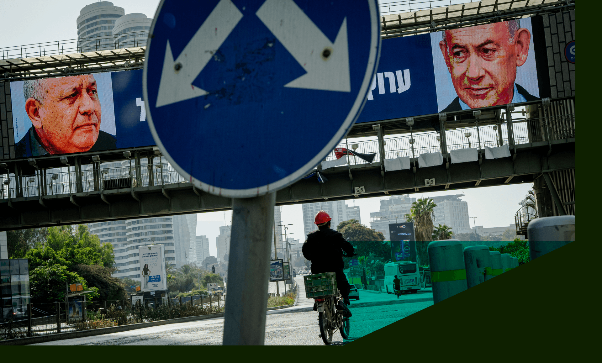 A cyclist rides beneath political advertisements in Tel Aviv, Israel.