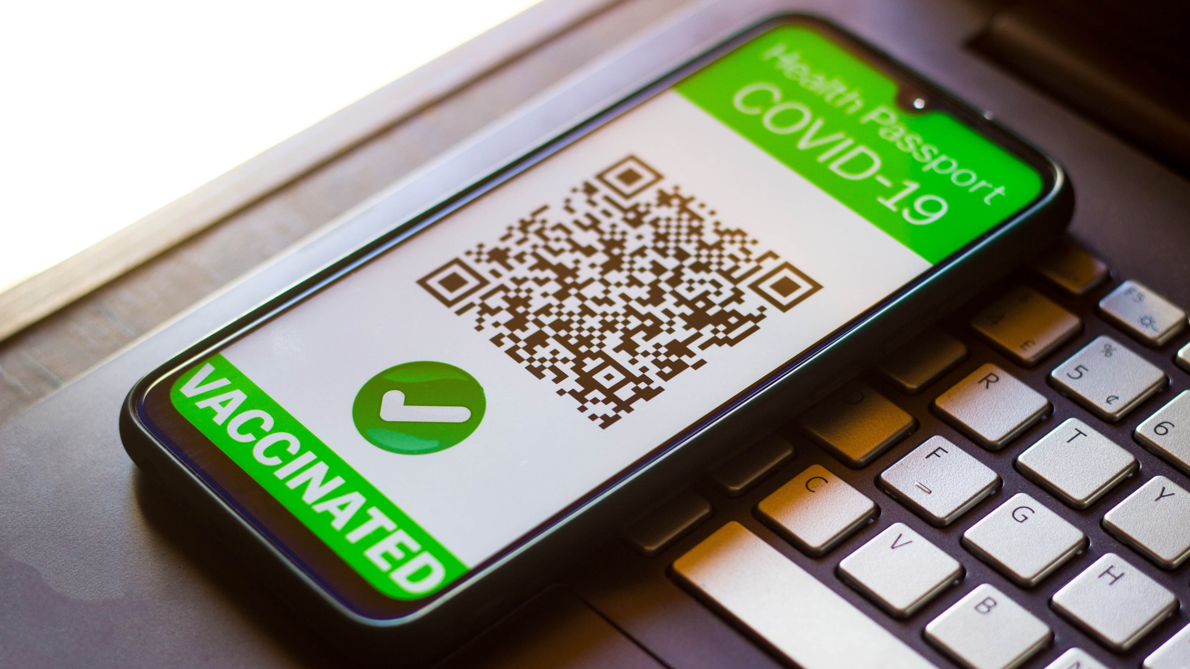 A symbolic COVID-19 health passport seen on a smartphone screen.