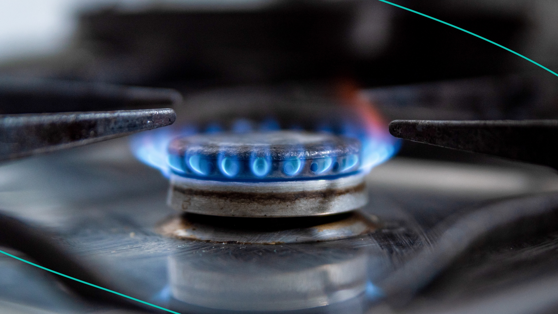A gas stove lets off a blue flame inside a household kitchen