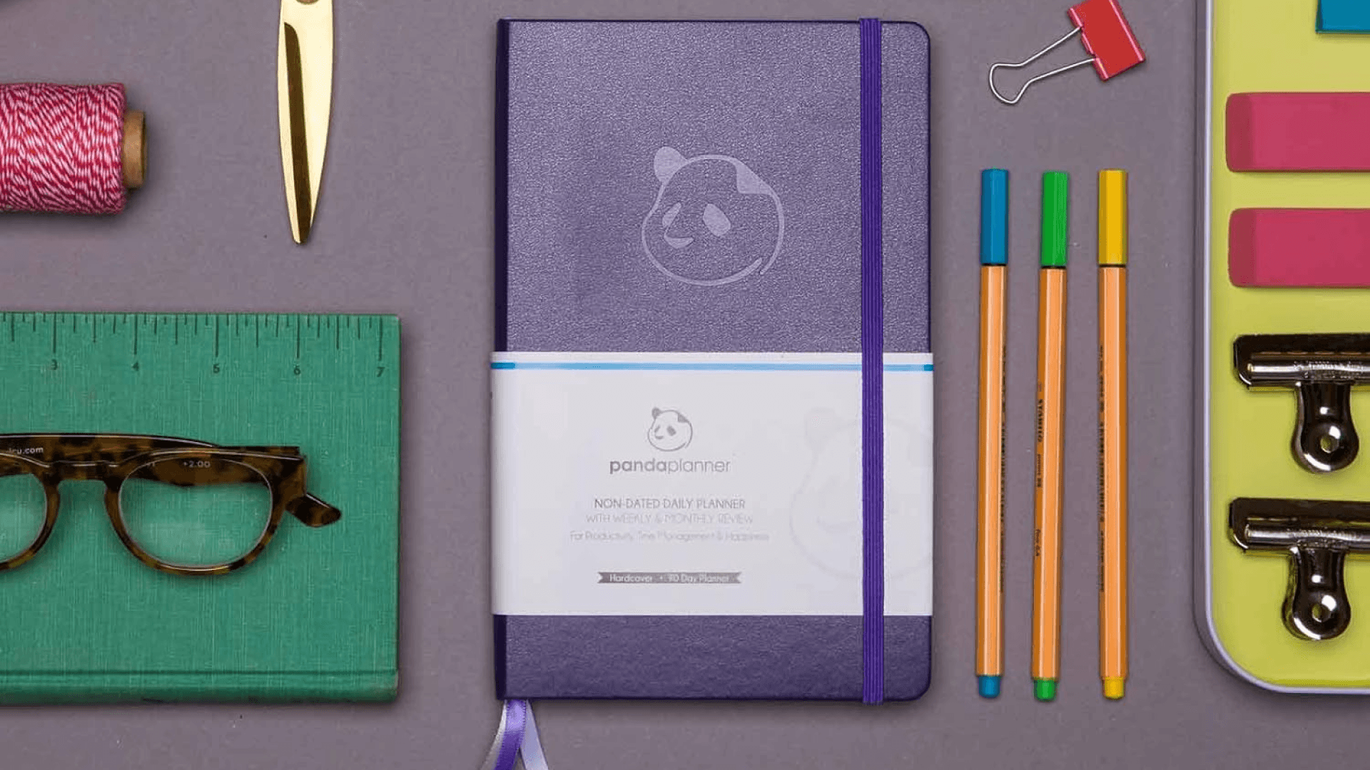 Purple planner with other office supplies