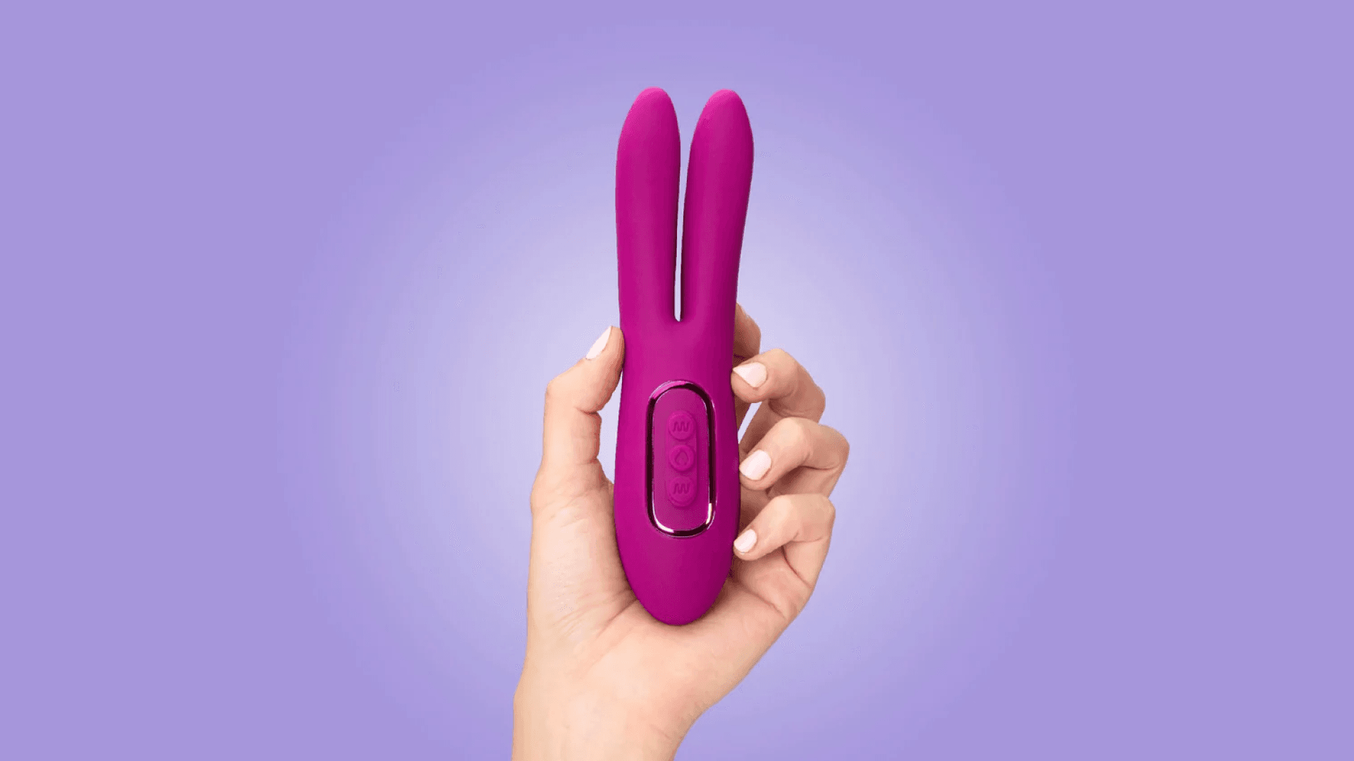 Hand holding pink vibrator with two ends on purple background