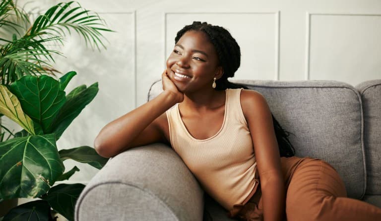 Shot of a beautiful young woman daydreaming at home; emotional permanence