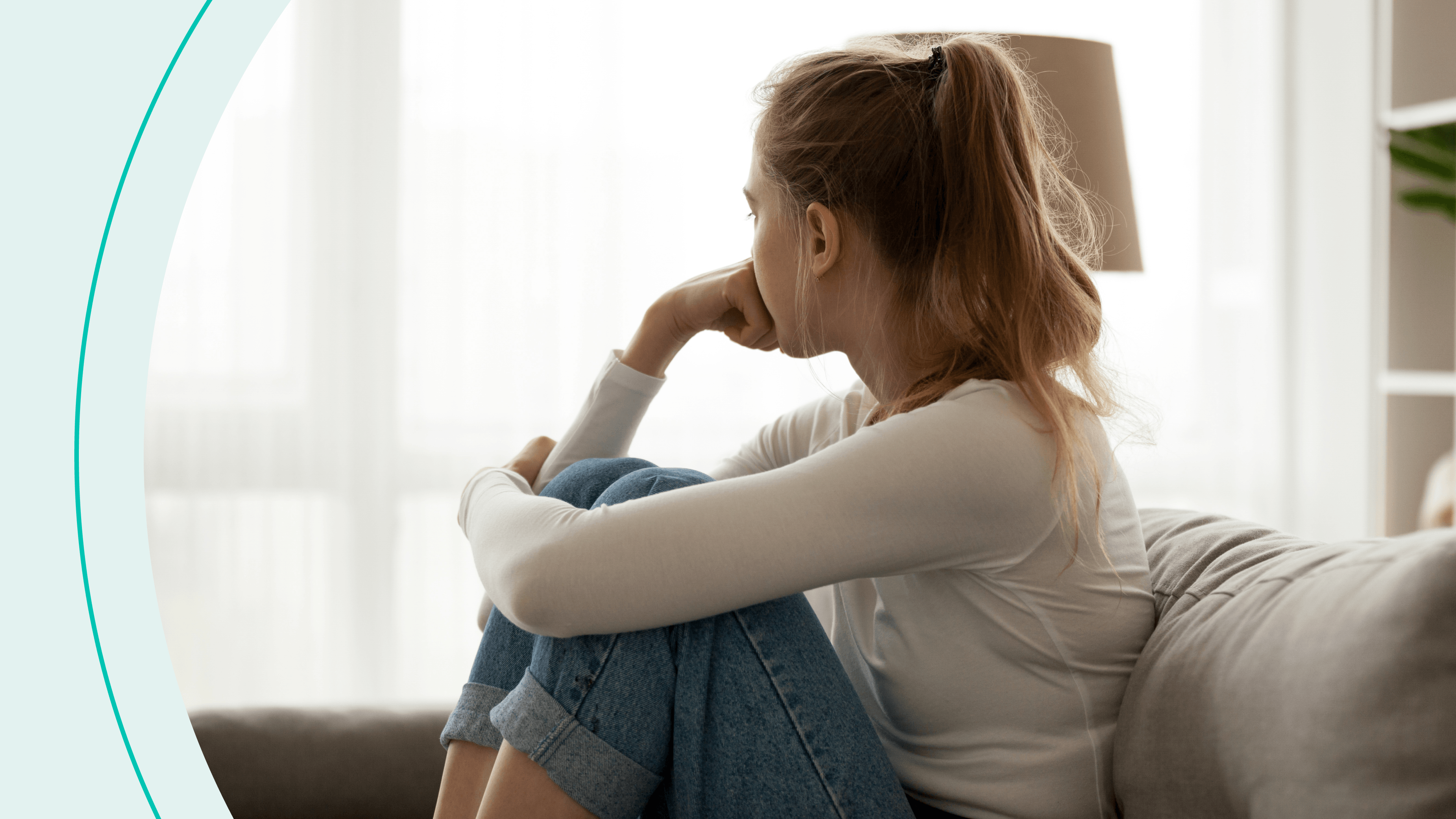 A woman sitting on a couch looking out the window