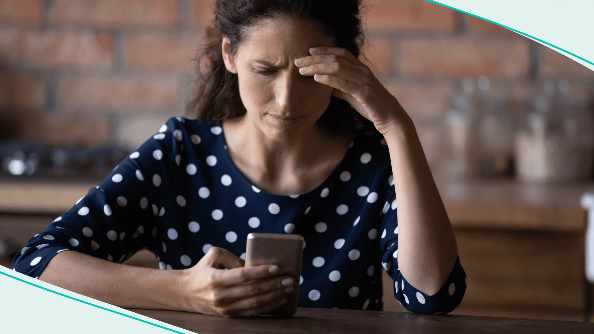Woman looking at phone with hand on face