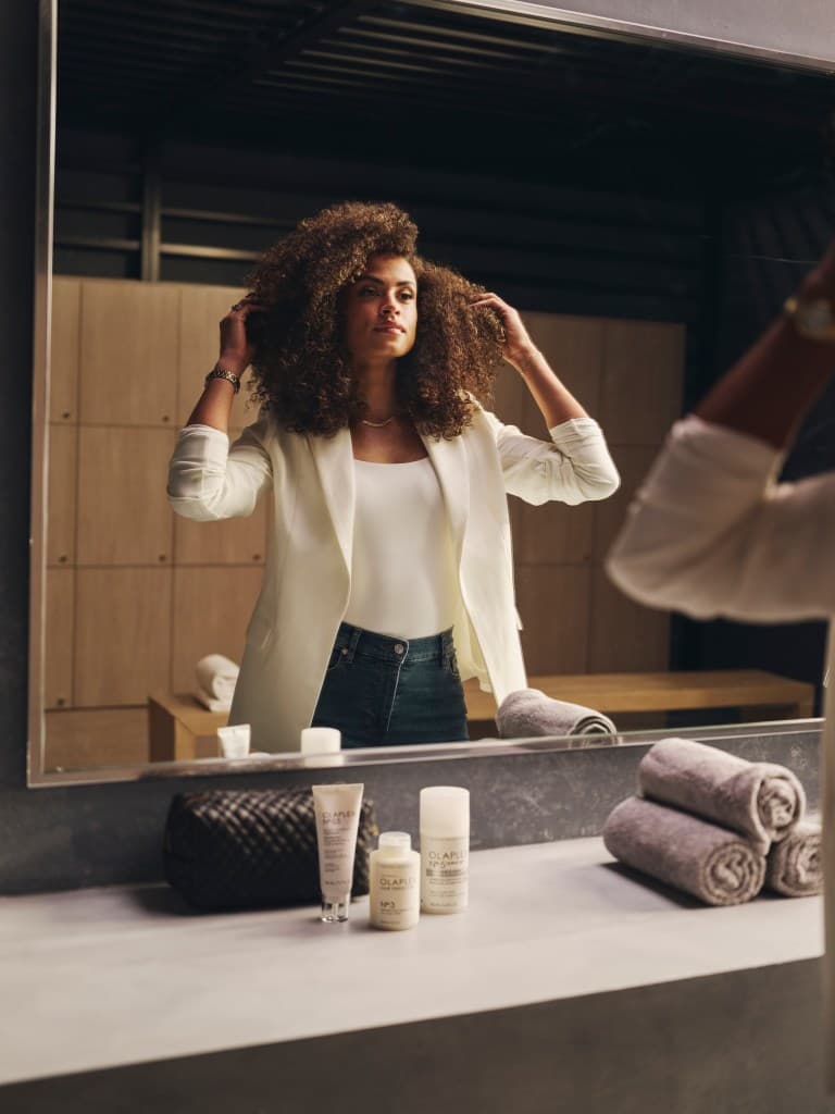 sydney mclaughlin-levrone taking care of her hair while looking in the mirror