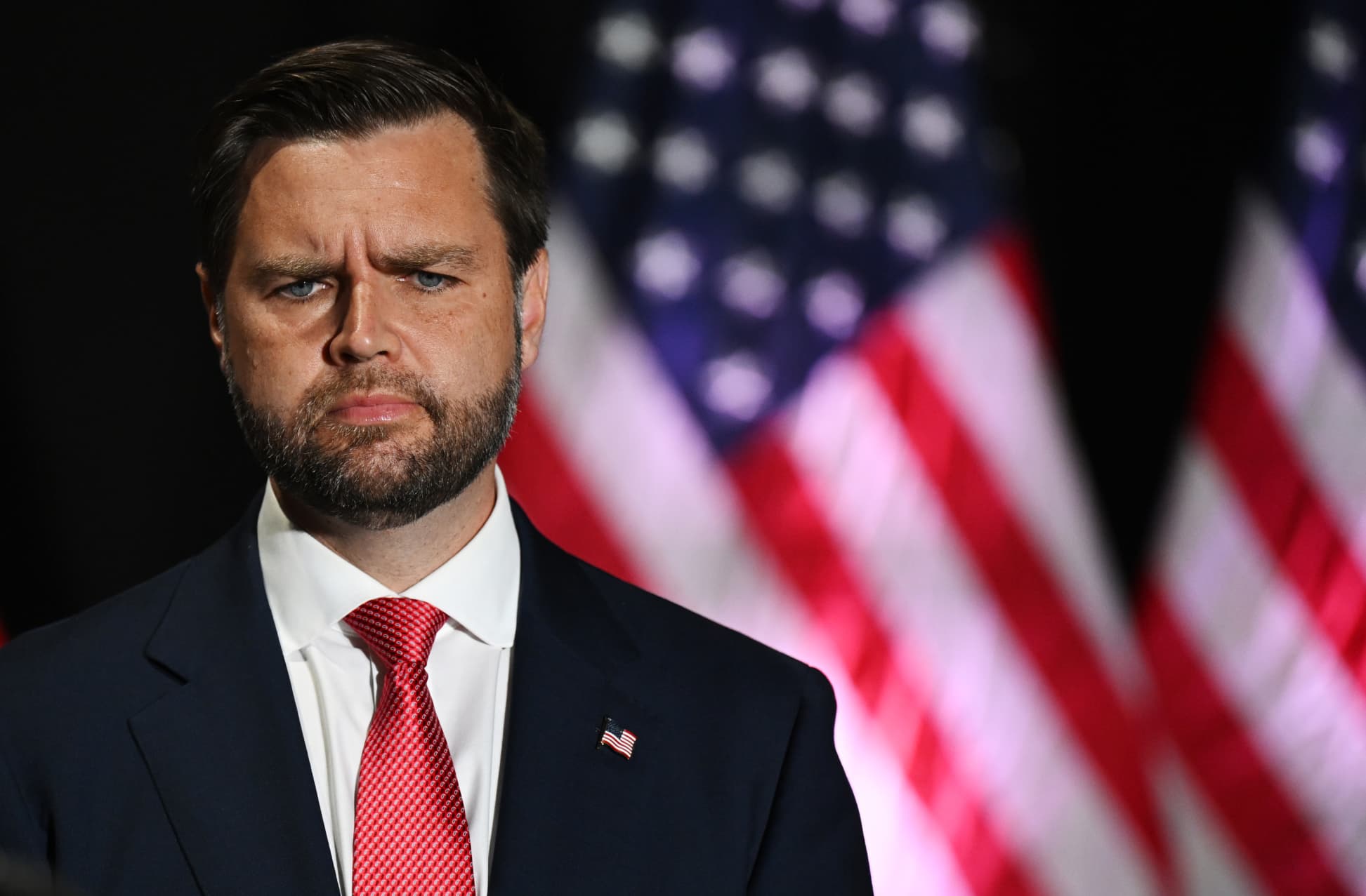 JD Vance standing in front of American flags